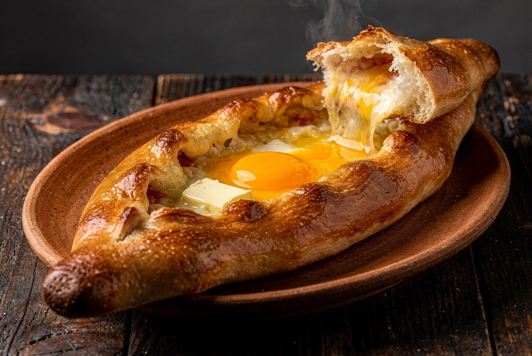 Adjarian khachapuri served hot with egg yolk and melting butter