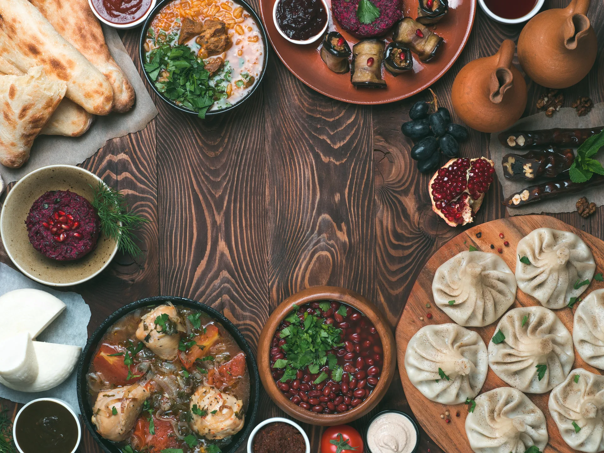 Georgian food spread on a wooden table with various cheese dishes and traditional accompaniments