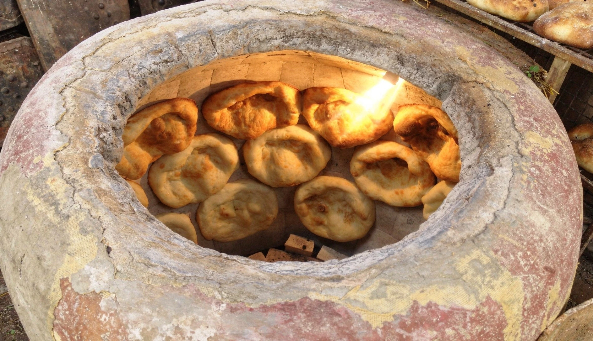 Freshly baked Georgian shotis puri bread on a wooden board with linen cloth