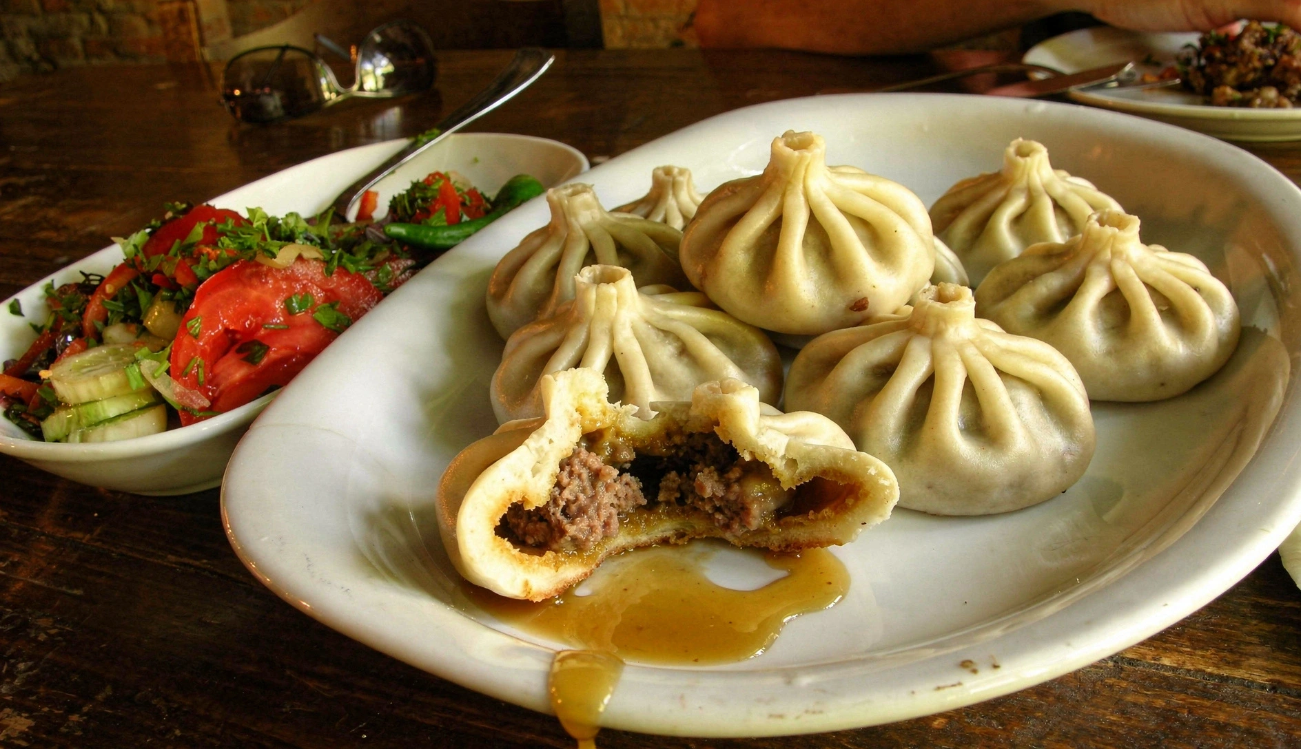 Freshly made khinkali Georgian soup dumplings with intricate pleating on traditional clay plate