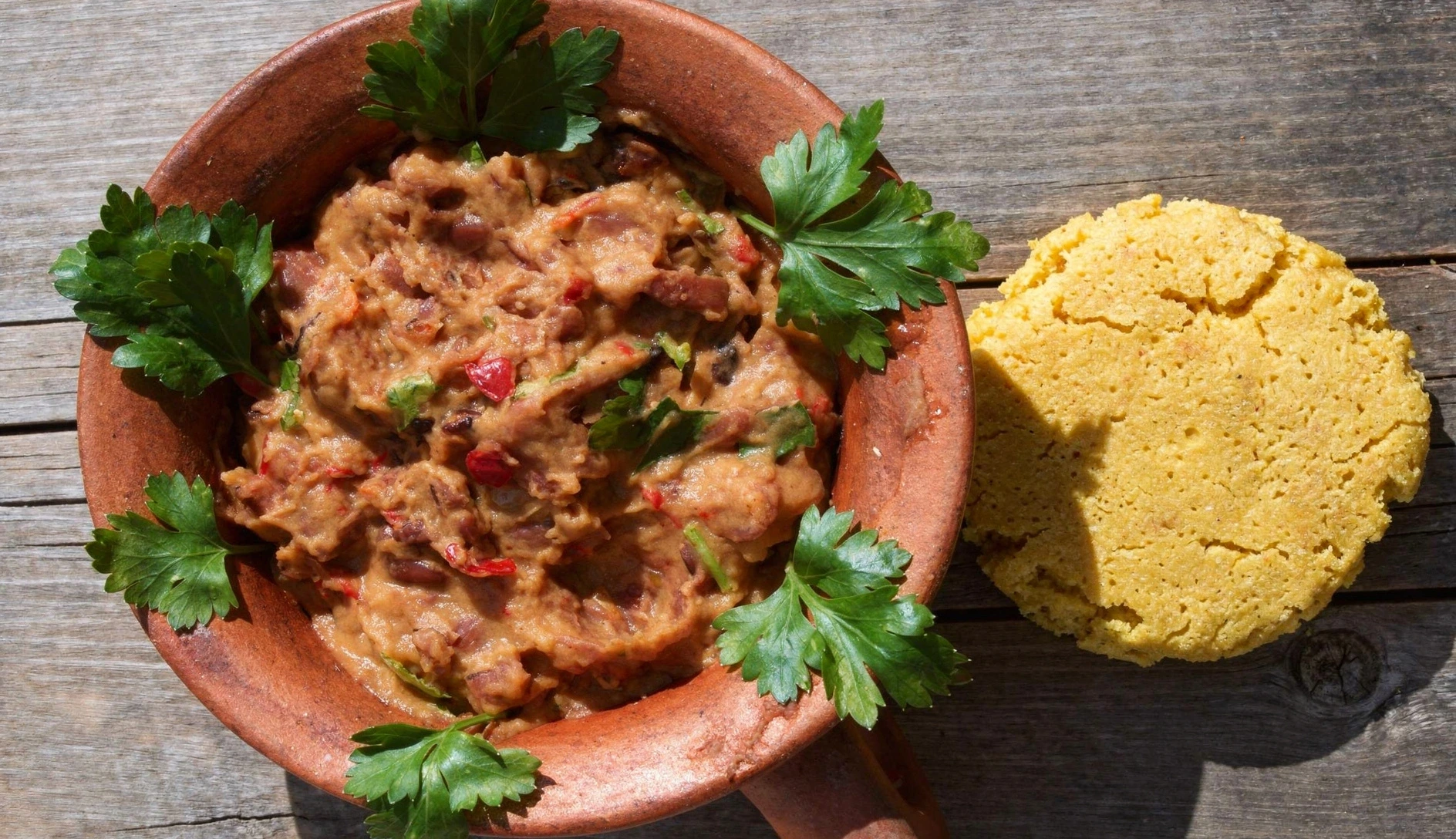Georgian supra feast table with lobio in clay pots, khachapuri, and skewered meats