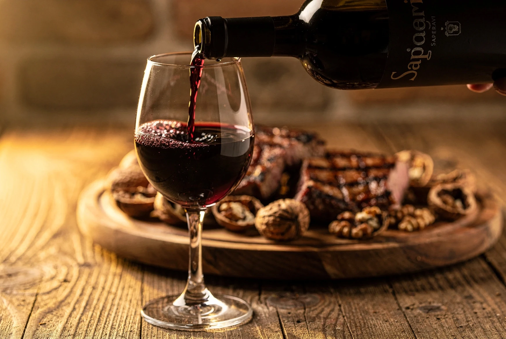 Georgian Saperavi being poured into a wine glass on a rustic wooden table