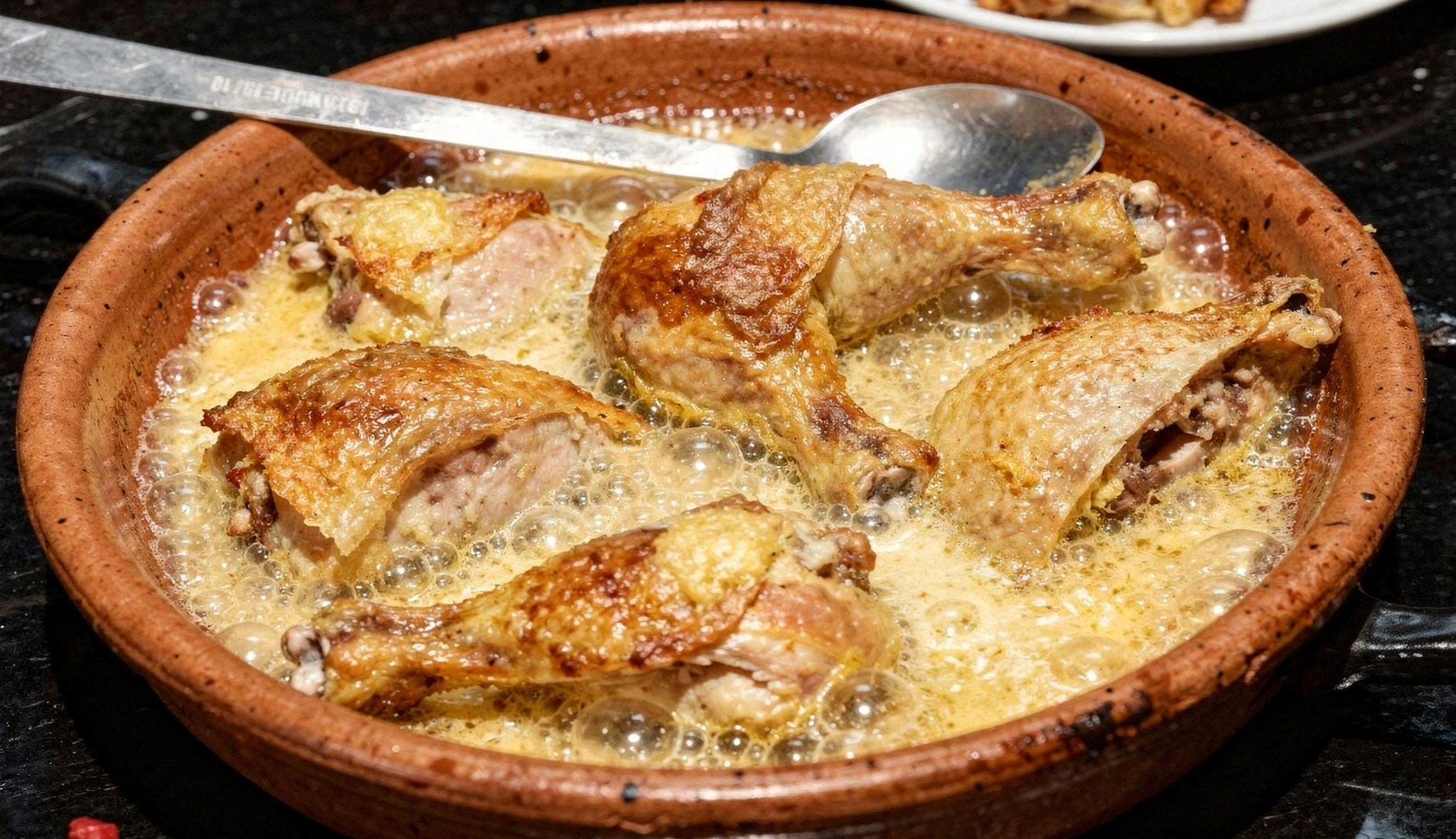 Shkmeruli Georgian garlic chicken in creamy milk sauce served in traditional clay ketsi