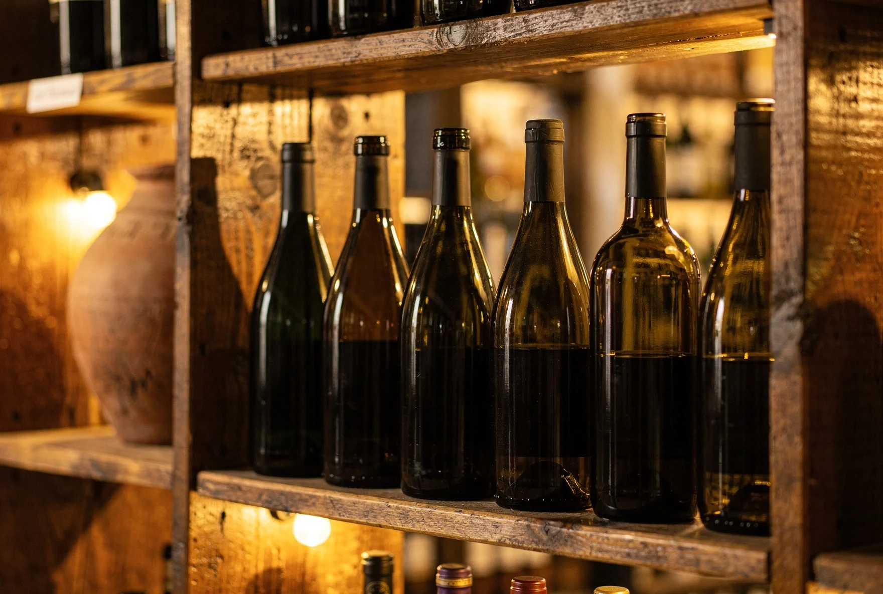 Georgian wine bottles arranged on wooden shelves in a wine shop